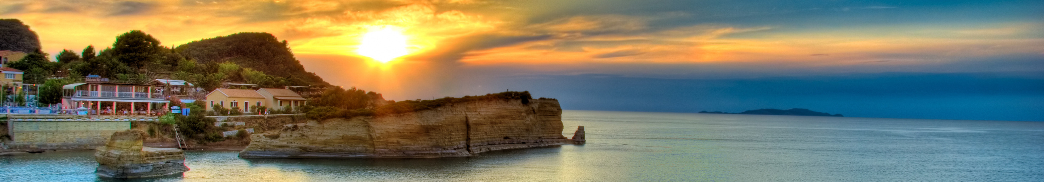 Sonnenuntergang an der Küste von Korfu in Griechenland mit Felsen und Meerblick