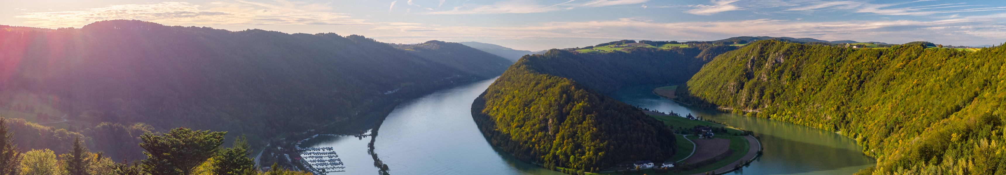Panoramablick auf die Donauschlinge bei Schlögen in Oberösterreich mit Fluss, Wald und Schiff bei Sonnenschein