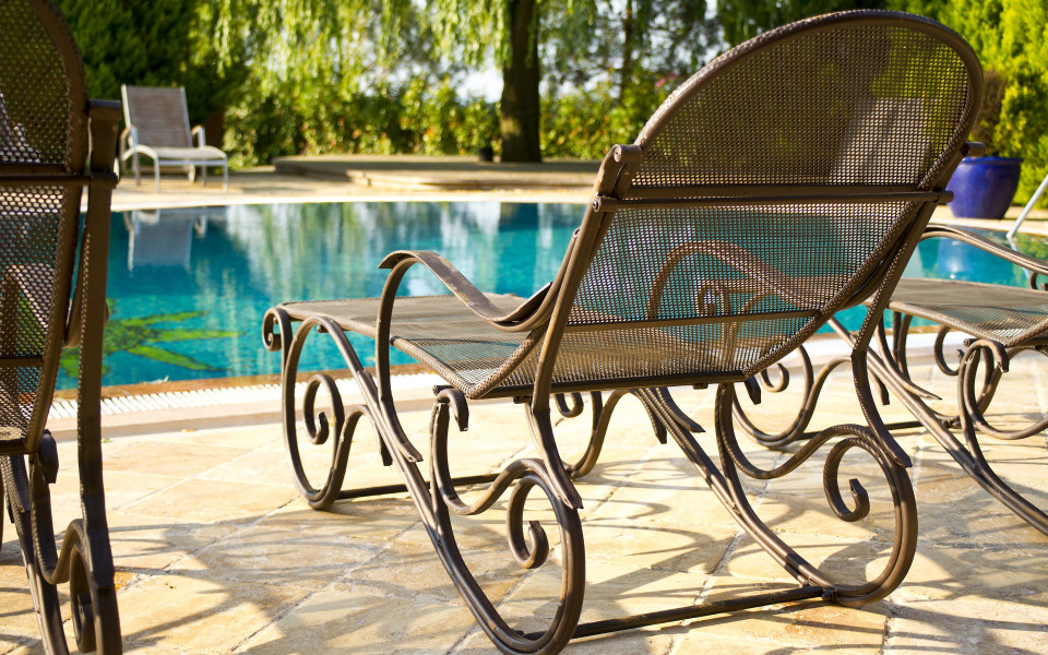 Pauschalurlaub: Antiker Liegestuhl am Pool 