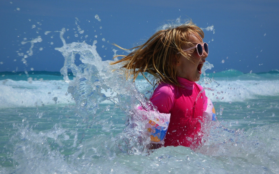 Kind mit Sonnenbrille im Meer
