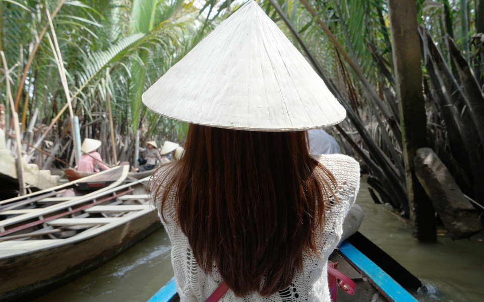 Frau mit Hut auf einem Boot auf dem Mekongstrom