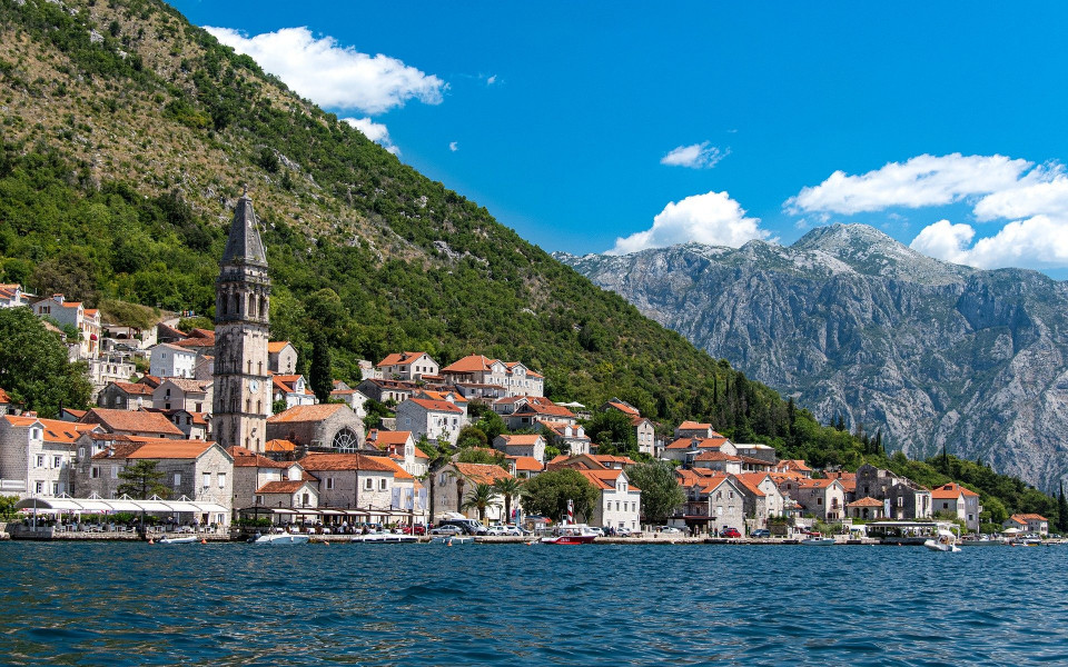 Küste mit Dorf und Kirchturm im Montenegro Urlaub am Meer