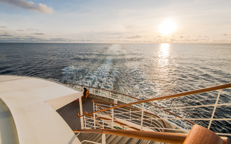 An Deck eines Kreuzfahrtschiffes mit Meerblick und Sonnenaufgang