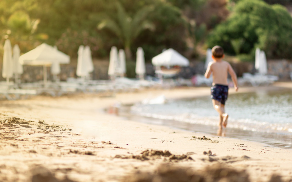 Junge läuft am Sandstrand entlang