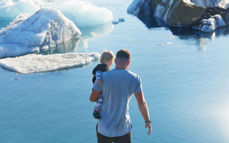 Mann mit Kind auf Eisberg in Island