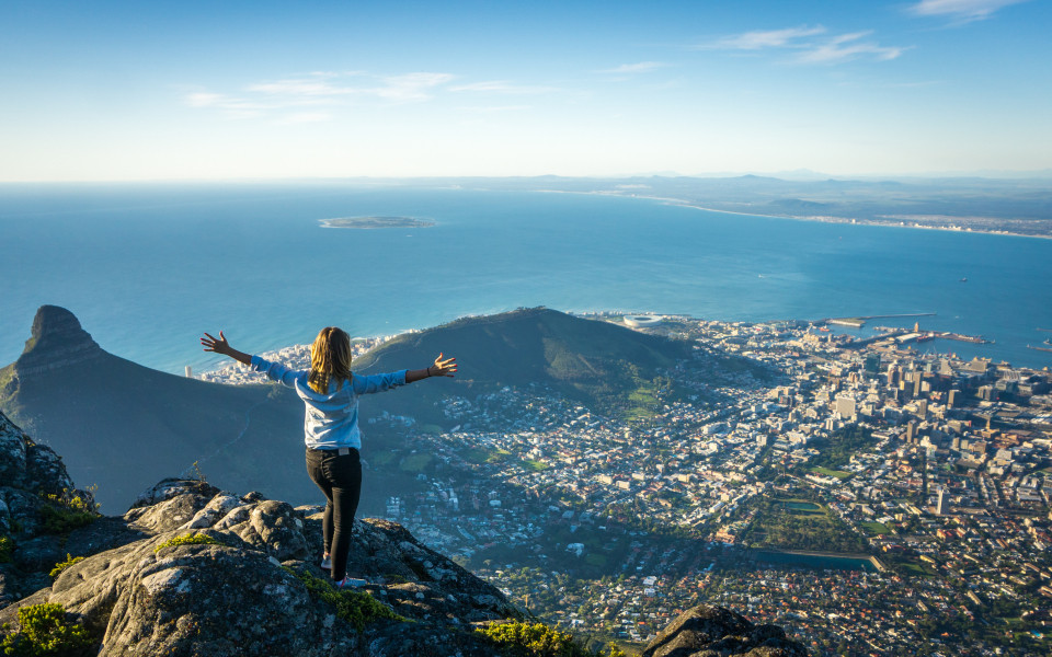 Frau auf einem Berg in Südafrika mit Meerblick und Stadtblick