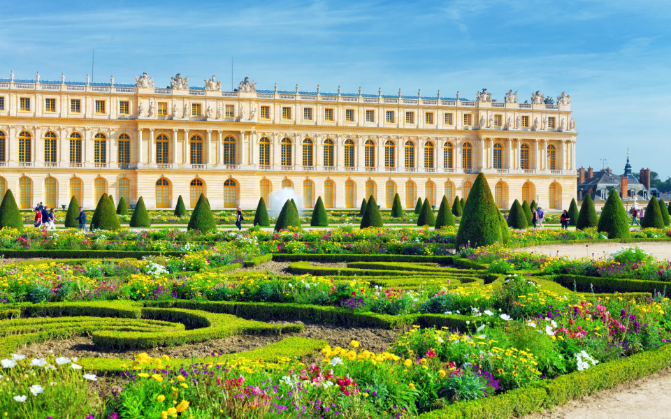 Prunkvolles Schloss Versailles bei Paris mit barockem Garten und farbenprächtigen Blumenbeeten.